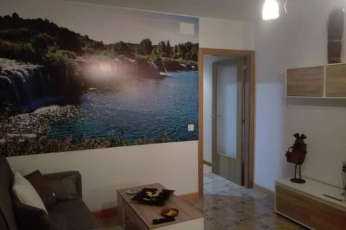 una sala de estar con una pintura en la pared en VIVIENDA VACACIONAL EL MOLINO ARGAMASILLA DE ALBA, en Argamasilla de Alba