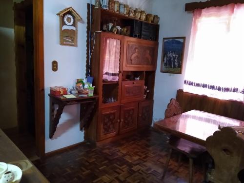Habitación con armario de madera y mesa. en Sítio Kanisfluh en Treze Tílias