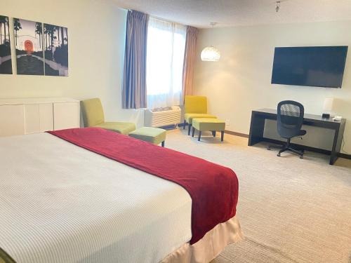 a hotel room with a bed and a flat screen tv at Redac Gateway Hotel Torrance in Torrance