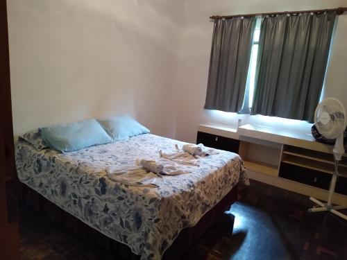 a bedroom with a bed and a window and a fan at Sítio Kanisfluh in Treze Tílias