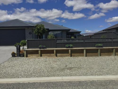 a house with a wooden fence and a yard at Sabai sabai 27 in Cromwell