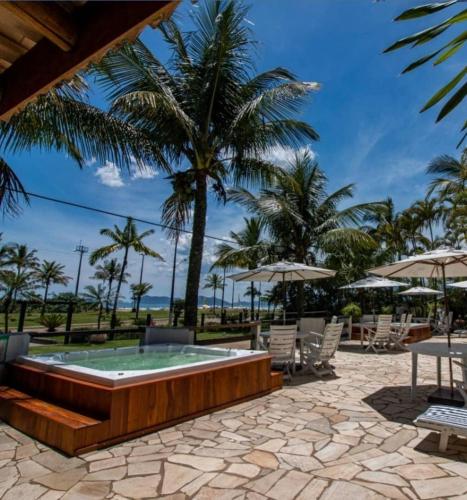 a pool at the resort with palm trees in the background at Apart Hotel Porto Kanoas in Bertioga
