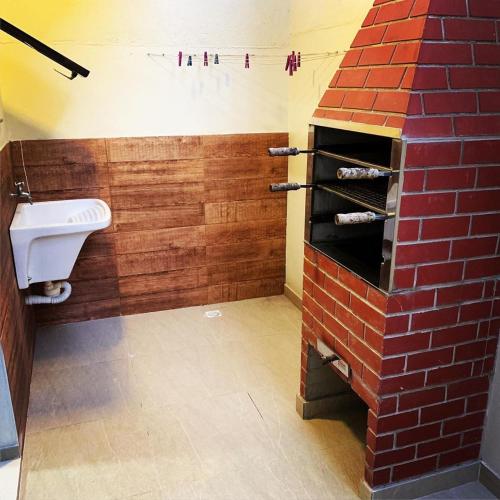 a bathroom with a sink and a brick wall at Apart Hotel Porto Kanoas in Bertioga