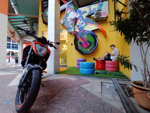 a motorcycle parked in front of a building with a man at masroom Hotel Kuala Lumpur in Kuala Lumpur