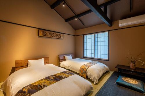 1 dormitorio con 2 camas y ventana en Kyoto Hiyori Mitake 日和御竹 en Kyoto