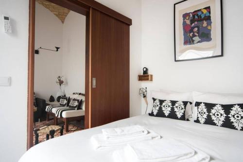 a bedroom with a white bed and a mirror at Casa Pombalinho, an old Fisherman Cottage in Fuzeta