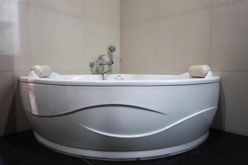 a white tub in a bathroom with a sink at Villa Melasti Wardana in Uluwatu