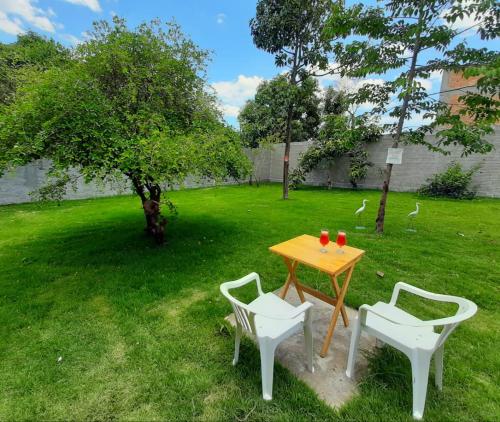 a wooden table and two chairs in a yard at Villa Flor e Cor in Cavalcante