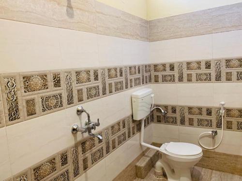 a bathroom with a toilet and a sink at Hotel Neelkanth in Jabalpur