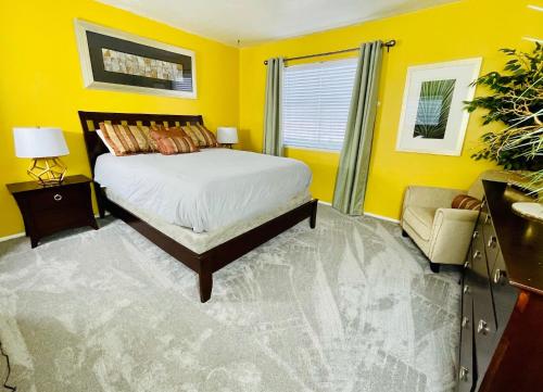 żółta sypialnia z łóżkiem i krzesłem w obiekcie Casas Adobes condo w mieście Tucson
