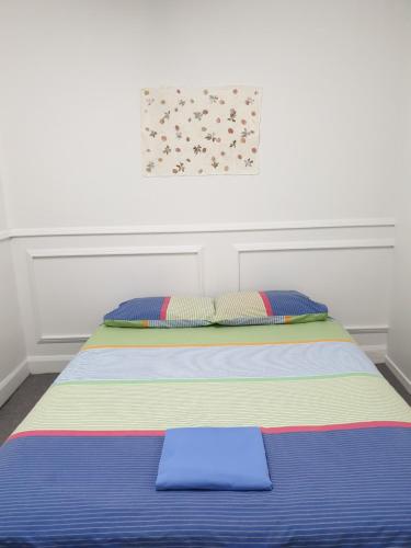 a bed with colorful sheets and pillows in a room at BK Hostel in Auckland