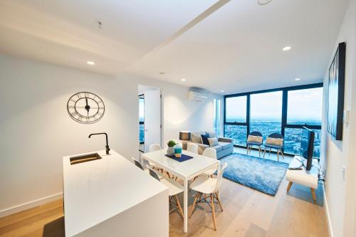 a kitchen and living room with a view of the ocean at Mega Style Apartments Victoria One in Melbourne