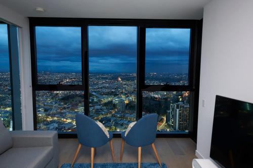 a living room with a view of a city at Mega Style Apartments Victoria One in Melbourne