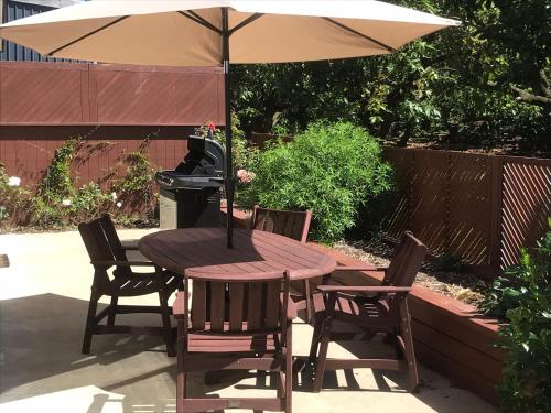 Baybell Lodge في تاورانجا: طاولة وكراسي خشبية مع مظلة