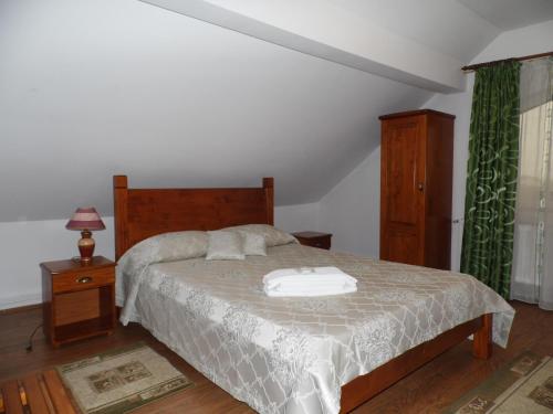 a bedroom with a large bed with a wooden headboard at Vilman House in Râşnov