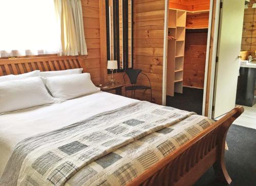 a bedroom with a bed and a table with a lamp at Duvauchelle Dream in Duvauchelle