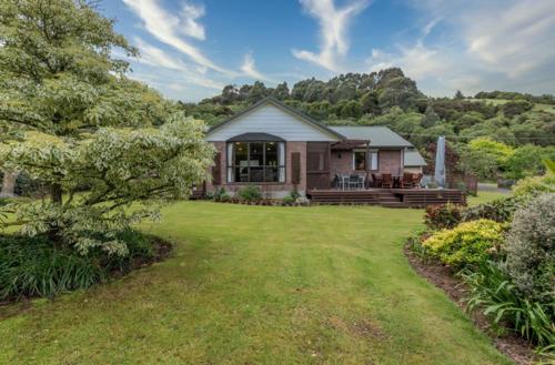 a home with a large yard with a house at Duvauchelle Dream in Duvauchelle