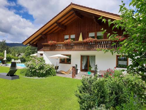 a house with a balcony and a swimming pool at Apartments Josef Seitz in Bayerisch Eisenstein