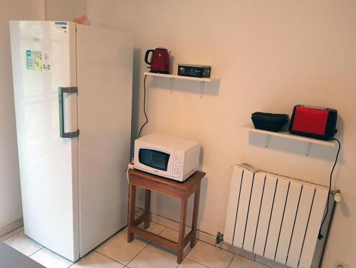 um micro-ondas sentado numa mesa ao lado de um frigorífico em Gîte Santenay les Bains em Saint-Sernin-du-Plain
