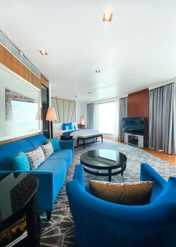 a living room with a blue couch and a table at InterContinental Marine Drive Mumbai by IHG in Mumbai