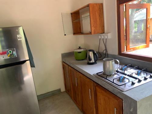 a kitchen with a stove and a refrigerator at Captain's Cottage at Yala in Kataragama