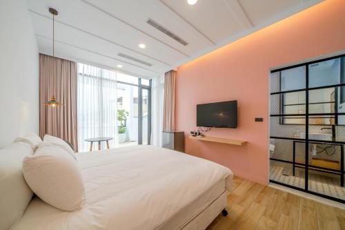 a bedroom with a large white bed and a tv at 鄢室民宿 in Hualien City