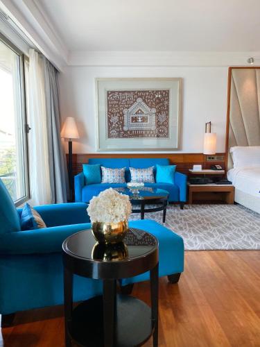 a living room with a blue couch and a bed at InterContinental Marine Drive Mumbai by IHG in Mumbai