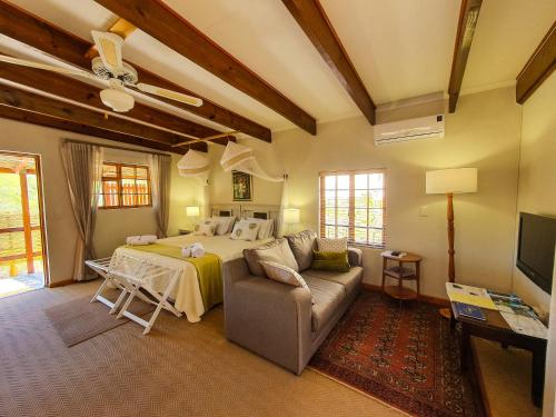 sala de estar con cama y sofá en Koppie Cottage en Prince Albert