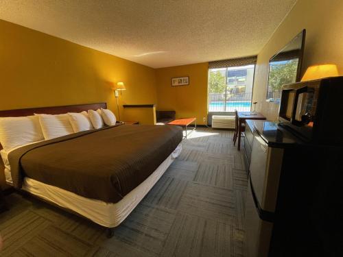 een hotelkamer met een bed en een flatscreen-tv bij Abilene Whitten Inn in Abilene