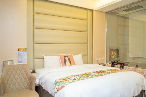 a bedroom with a large white bed and a chair at Skylight bnb in Yuchi