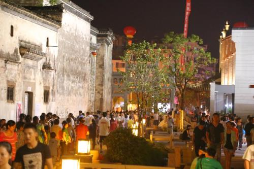 a crowd of people walking down a street at night at Mild Spring Boutique Hotel in Huangshan