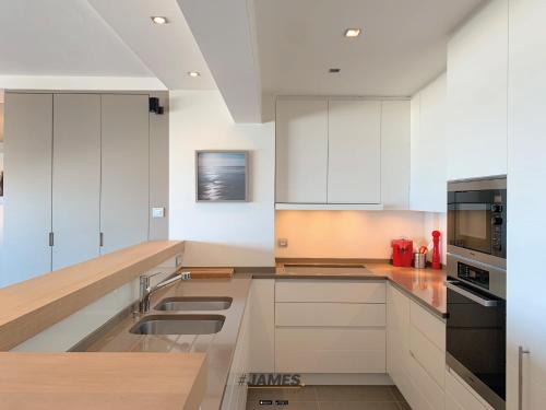 
A kitchen or kitchenette at Heerlijk luxe appartement met frontaal zeezicht
