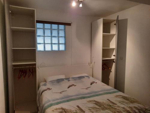 a bedroom with a bed and shelves and a window at appartement seafront in Ostend