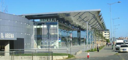 a woman walking in front of a large building at soukromý pokoj in Prague
