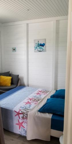 a bedroom with a bed and a couch in it at Séjournez au coeur des Tropiques Bungalow 2 chambres avec Piscine proche de la mer in Sainte-Anne