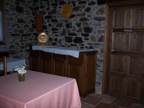 Zimmer mit einem Tisch und einer Steinmauer in der Unterkunft Casa Rafeleta Hotel in Plan