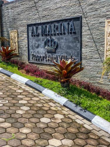 a sign on the side of a brick building at AL Marina Resort in Puncak