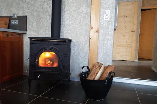 a black stove in a kitchen with a room at Chez Papy - Grand Appart Entirely renovated Ventelon La Grave La Meije in La Grave