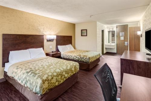 a hotel room with two beds and a desk at Econo Lodge Inn & Suites in Binghamton