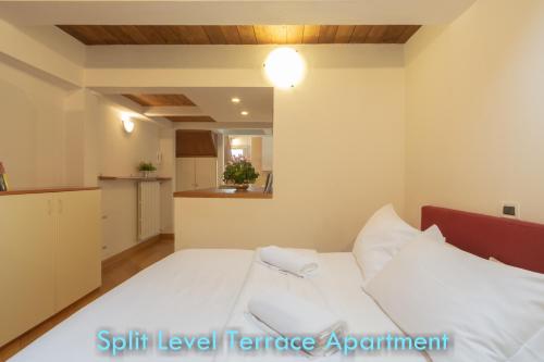 a bedroom with a white bed and a kitchen at BolognaRoomscom - Santo Stefano Apartments in Bologna
