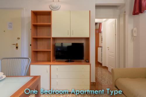 a living room with a tv on a entertainment unit at BolognaRoomscom - Santo Stefano Apartments in Bologna