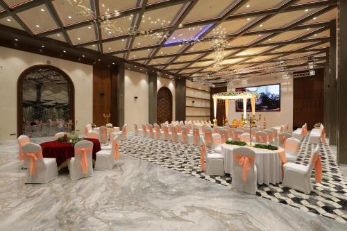 ein Bankettsaal mit weißen Tischen und weißen Stühlen in der Unterkunft Tara Suns in Vadodara