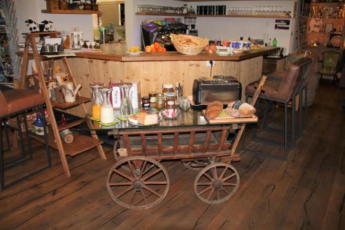 un carrello di legno con un tavolo con sopra del cibo di B&B Hängebrigga a Ernen