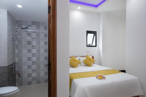 a white bedroom with a bed and a shower at Kim Hoàn Hotel Phan Rang in Phan Rang