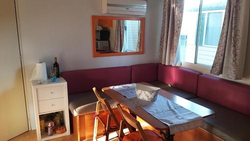 ein Wohnzimmer mit einem roten Sofa und einem Tisch in der Unterkunft Casetta nel verde in Ameglia