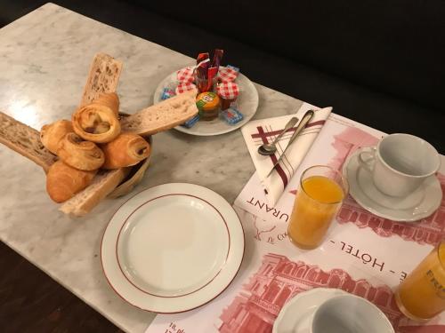 a table with plates of food and a cup of orange juice at Hostellerie du Coq d'Or in Jonzac