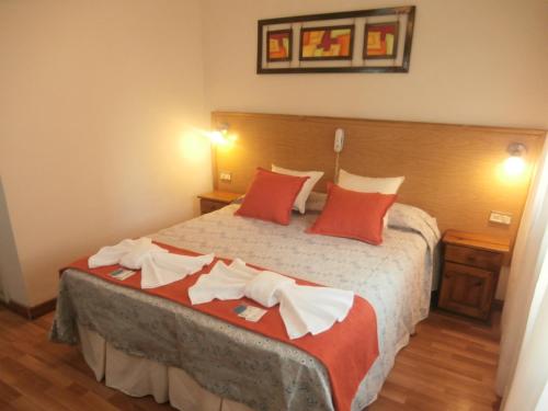 a bedroom with a large bed with red pillows at Hotel Alma di Mare in Mar del Plata