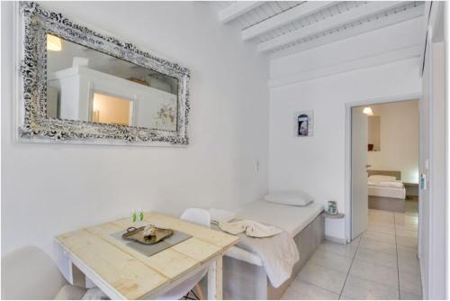 a white room with a table and a mirror at Traditional Cycladic House in Tripití