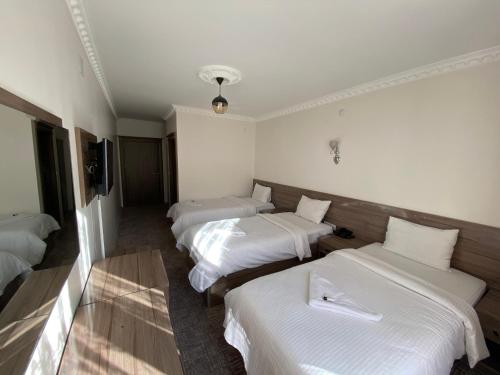 Un pat sau paturi într-o cameră la Toprak Hotel