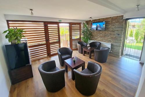 a living room with chairs and a flat screen tv at Sinjirite Complex in Elena